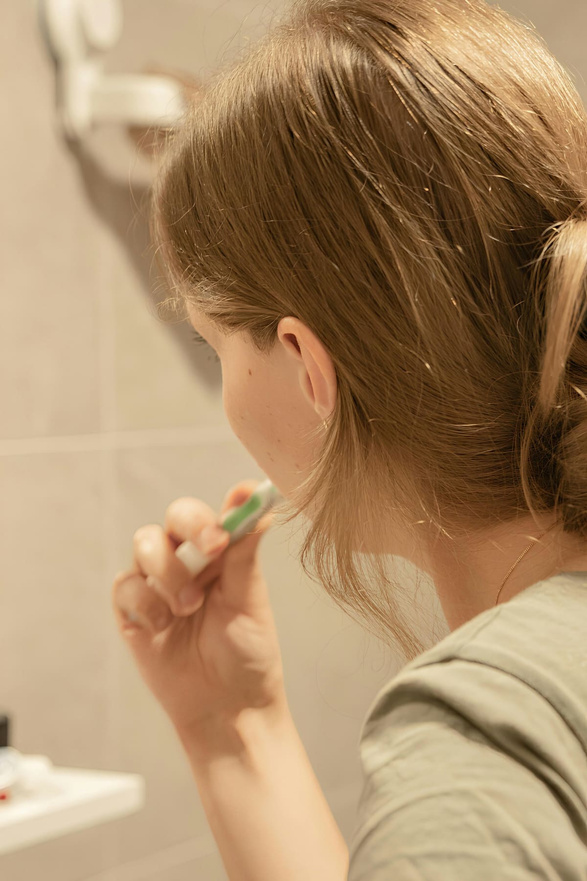Femme se brossant les dents dans la salle de bain