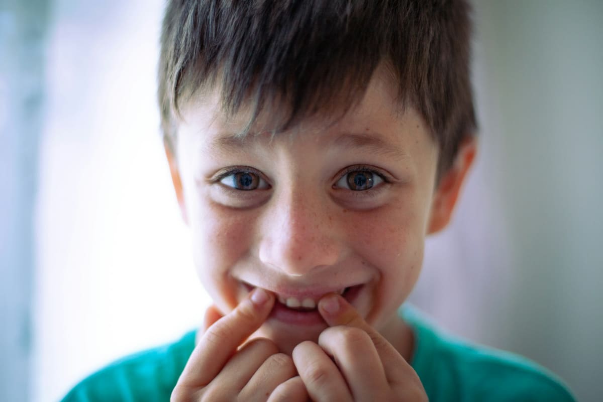 Jeune garçon avec une brosse à dents dans la bouche